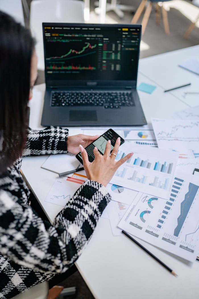 journey Businesswoman evaluating stock market trends using graphs and smartphone in office.